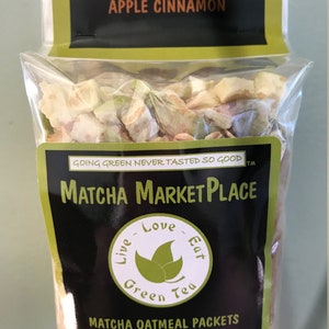 May include: A package of six individual servings of apple cinnamon matcha oatmeal packets. The packaging is black with green accents and the text "Matcha Marketplace" and "Live Love Eat Green Tea".