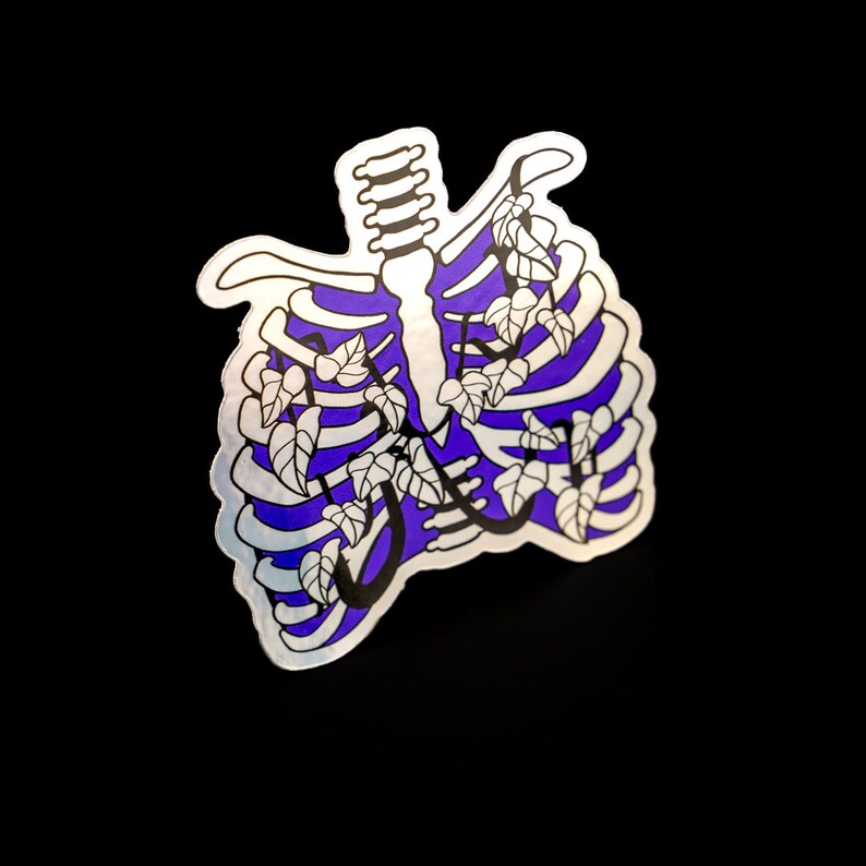 May include: A silver sticker featuring a purple and black outline of a ribcage with white leaves growing inside.