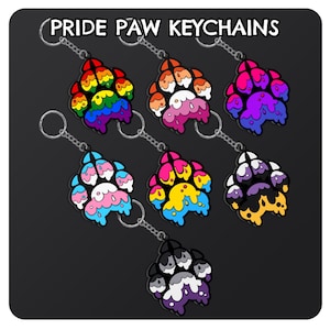 May include: Set of 7 pride paw print keychains. Each keychain features a different pride flag color scheme with a paw print design and a dripping effect. The keychains are attached to silver key rings.