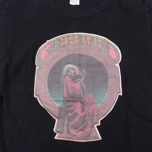 May include: Black t-shirt with a graphic print of a skeleton playing a guitar. The graphic is in a circular frame with the text "GRATEFUL DEAD" above it.