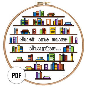 May include: A cross-stitch design in a wooden hoop features a bookshelf with colourful books. The text "Just one more chapter..." is centered below the shelves. A PDF icon is in the lower left.