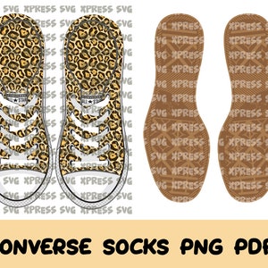 May include: A pair of white Converse sneakers with a leopard print design. The soles of the shoes are brown.
