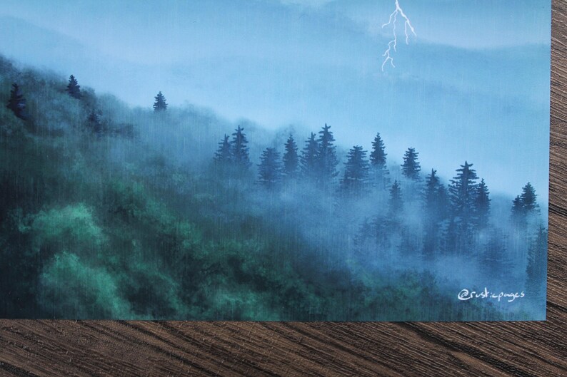 以下が含まれることがあります： 霧のかかった森を描いた絵画。濃い緑色の木々と青い空が特徴です。遠くには稲妻が走っています。作品は右下に「@rustiapages」とサインされています。