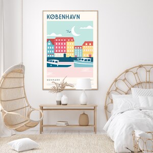 May include: A colourful poster featuring a stylised illustration of buildings and boats in Copenhagen, Denmark. The poster has a blue sky with white clouds and a crescent moon. The text "KØBENHAVN" is at the top of the poster, and "DENMARK" is at the bottom.