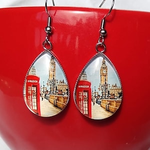 May include: A pair of silver teardrop-shaped earrings with a glass cabochon featuring a colorful image of Big Ben and a red telephone booth in London, England.