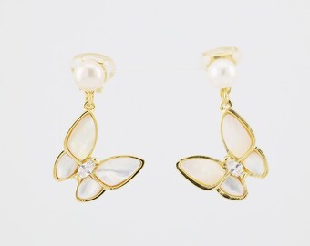 Puede incluir: Un par de pendientes de mariposa de oro con detalles de perlas blancas. Los pendientes presentan un delicado diseño de mariposa con un cristal transparente en el centro de cada ala.