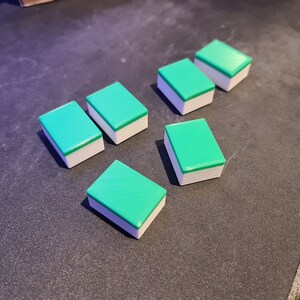 May include: Six green and white rectangular tiles with rounded edges. The tiles are arranged in a staggered pattern.
