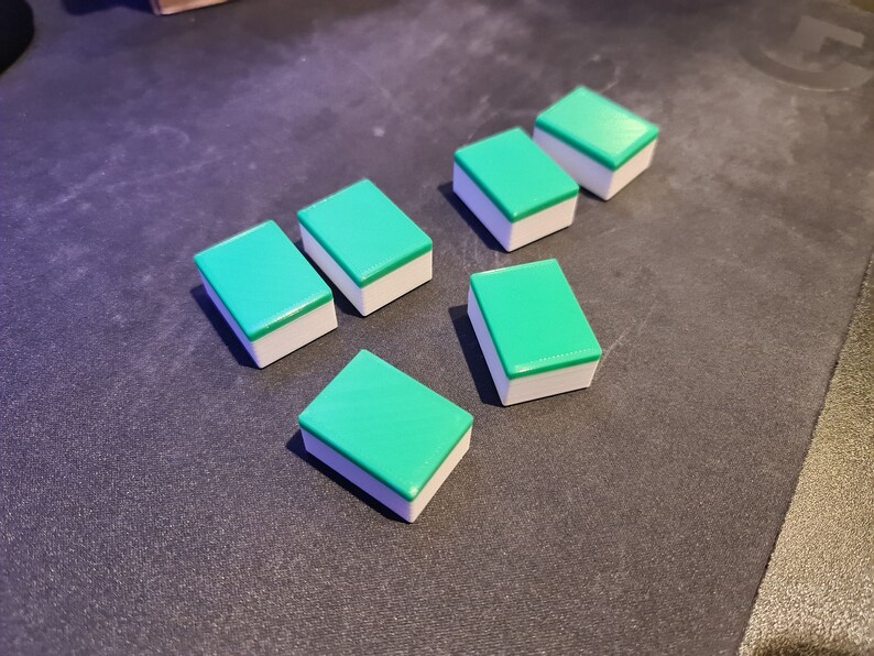 May include: Six green and white rectangular tiles with rounded edges. The tiles are arranged in a staggered pattern.
