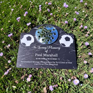 Puede incluir: Placa conmemorativa de mármol negro con gráficos de balón de fútbol y un florero. La placa dice "In Loving Memory of Paul Marshall" con fechas y espacio para un mensaje personalizado.