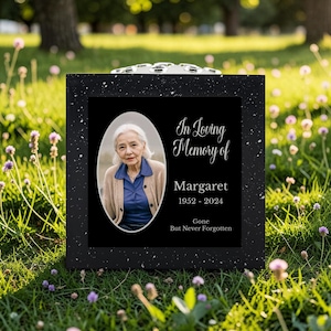 Op de afbeelding: Zwarte gedenkplaat met een gespikkelde rand. De plaat toont een foto van een vrouw in een ovale lijst, met de tekst "In Loving Memory of Margaret 1952-2024 Gone But Never Forgotten."