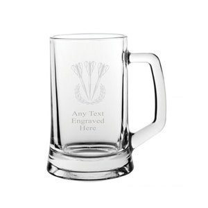 May include: A clear glass beer mug with a handle. The mug is engraved with three darts and a laurel wreath. The text "Any Text Engraved Here" is also engraved on the mug.