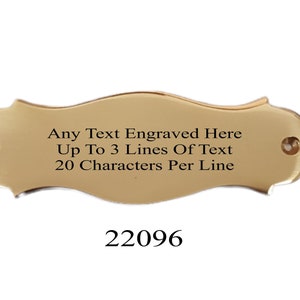 Könnte beinhalten: Eine goldfarbene Metallplakette mit einer wellenförmigen Form und abgerundeten Kanten. Die Plakette hat auf jeder Seite zwei kleine Löcher. Der Text "Any Text Engraved Here Up To 3 Lines Of Text 20 Characters Per Line" ist in die Plakette graviert. Die Nummer "22096" ist unter der Plakette gedruckt.