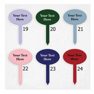 Op de afbeelding: Zes ovale tuinmarkeringen met verschillende gekleurde toppen en de tekst "Your Text Here" op elk. De markeringen zijn genummerd van 19 tot en met 24.