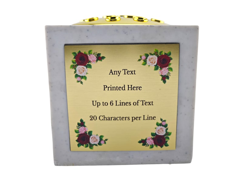 May include: A square, light gray memorial urn with a gold-colored plaque. The plaque has floral corner accents and the text "Any Text Printed Here Up to 6 Lines of Text 20 Characters per Line". The top has gold accents.