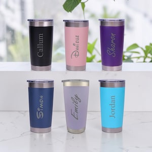 May include: Six stainless steel tumblers with clear lids, arranged in two rows. The colours are black, pink, purple, navy blue, lavender, and light blue. Each tumbler features a unique name engraved vertically: Callum, Danielle, Sharon, Simon, Emily, and Jordan.