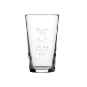 May include: A clear glass pint glass with a golf-themed engraving. The design includes a golf ball, golf clubs, and a flag. The text "Any Text Engraved Here" is below the golf graphic.