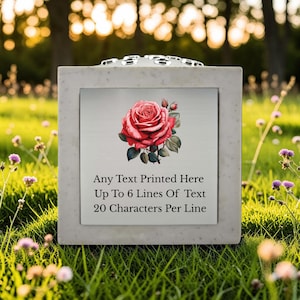 May include: A white ceramic mug with a black handle and the text "But First, Coffee" in a bold, black font. The mug is set against a blurred background, suggesting a cozy setting.
