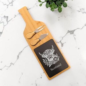 Juego de tabla de quesos de madera con forma de botella y diseño de vaca de las Tierras Altas grabada, con pizarra rectangular, estilo escocés.