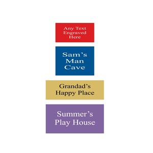 May include: Four rectangular signs with different text on each. The top sign is red and says "Any Text Engraved Here". The second sign is blue and says "Sam's Man Cave". The third sign is gold and says "Grandad's Happy Place". The bottom sign is purple and says "Summer's Play House".