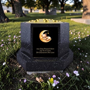Op de afbeelding: Een zwart granieten gedenkteken met een goudkleurige bovenkant. Het voorpaneel toont een afbeelding van een slapende teddybeer op een maan. Tekst: "Any Text Printed Here Up To 4 Lines 20 Characters Per Line."