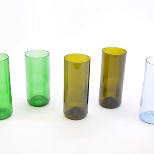 Può includere: Cinque bicchieri da bere in vetro, due verdi, due marroni e uno blu. Tutti i bicchieri sono della stessa dimensione e forma.