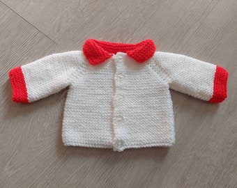 Jacket in white with red trim with button fastening down the front, acrylic yarn and machine washable for large premature baby