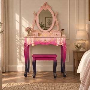 May include: A vanity table and matching stool featuring an ombre finish that transitions from light pink at the top to deep magenta and dark purple at the base. The vanity includes an oval mirror with ornate carvings and gold floral accents.