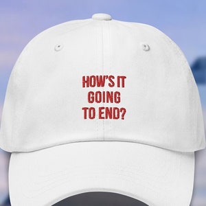 Könnte beinhalten: Weißes Baseball-Cap mit dem roten Text "HOW'S IT GOING TO END?". Die Kappe hat einen gebogenen Schirm und ein klassisches Sechs-Panel-Design. Der Text ist mittig auf der Vorderseite platziert.