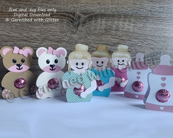 May include: Set of six printable baby shower favor boxes featuring a teddy bear, a girl holding a baby, and a baby bottle. The boxes are designed to hold small treats or favors. The text "fc and .svg files only Digital Download @Garnished with Glitter" is visible in the image.