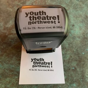 Pu&ograve; includere: Un timbro in bianco e nero con il testo "youth theatre! northwest" e l'indirizzo "P.O. Box 296 - Mercer Island, WA 98040".