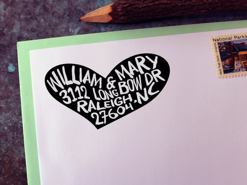 May include: A black and white heart-shaped sticker with the text "WILLIAM & MARY 3112 LONG BOW DR RALEIGH.NC 27604" on a white background.