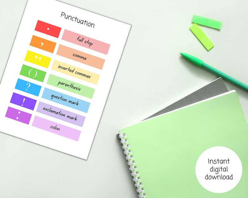 May include: A printable worksheet with a rainbow color scheme, listing different punctuation marks and their names. The text "Punctuation" is at the top of the page. The worksheet is on a white surface with a green notebook and two green sticky notes.
