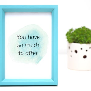 Peut inclure: Une impression encadr&eacute;e avec un cadre bleu clair et un fond blanc. L'impression pr&eacute;sente un design de style aquarelle avec le texte "You have so much to offer".