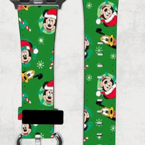 Könnte beinhalten: Ein grünes Apple Watch Armband mit einem Weihnachtsmuster mit Mickey Mouse und Zuckerstangen. Das Armband ist aus Leder und hat eine silberne Schnalle.