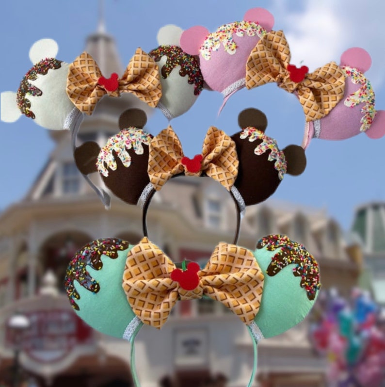 May include: Three pairs of Minnie Mouse ears with ice cream cone designs. The ears are made of felt and feature a waffle cone bow. The ice cream cones are in pink, brown, and green.