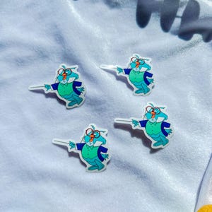 May include: Four blue and green cartoon owl stickers with a conductor's baton. The owls are wearing glasses and a tuxedo. The stickers are on a white surface.