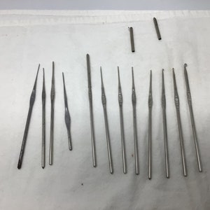 May include: A set of 17 silver crochet hooks of various sizes. The hooks are laid out on a white surface.
