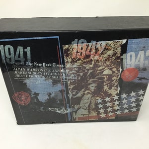 May include: A black box with a collage of images and text from 1941, 1942, and 1943. The text includes "The New York Times" and "JAPAN WARS ON U.S. AND BRITAIN MAKES SUDDEN ATTACK ON HAWAII HEAVY FIGHTING AT SEA REPORTED".
