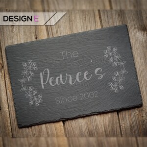 May include: Black slate sign with the text "The Pearce's Since 2002" in white lettering. The text is surrounded by a decorative floral design.