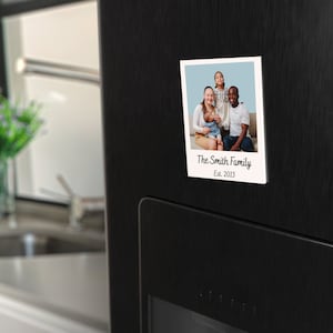 May include: A white photo frame with a picture of a family of four. The frame has a white border and the text "The Smith Family Est. 2013" printed on the bottom.