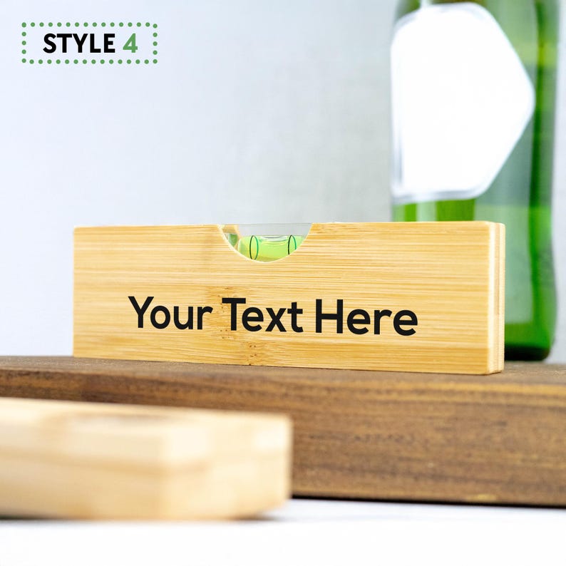 K&ouml;nnte beinhalten: Ein Holz-Wasserwaage mit einer gr&uuml;nen Libelle und dem Text "Your Text Here" auf der Vorderseite graviert. Die Wasserwaage ist aus Bambus und hat eine nat&uuml;rliche Holzoptik.