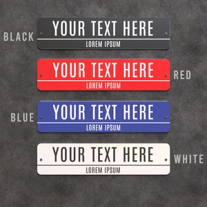May include: Four rectangular signs in black, red, blue, and white. Each sign has the text "YOUR TEXT HERE" in white, with "LOREM IPSUM" below. The signs are mounted with rivets and are labelled "BLACK", "RED", "BLUE", and "WHITE".