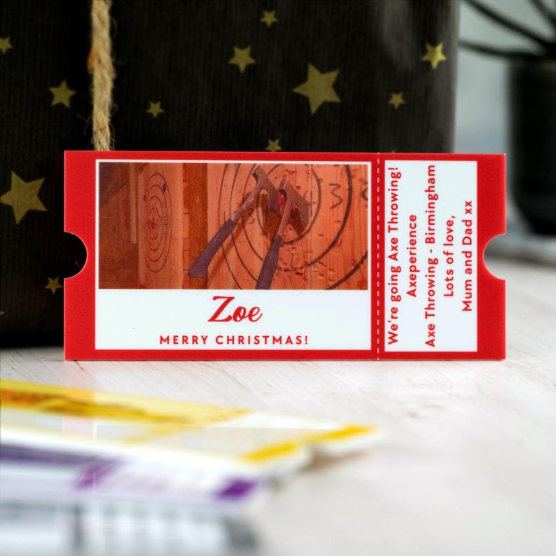 May include: Red and white Christmas gift certificate for an axe throwing experience in Birmingham. The certificate says "We're going Axe Throwing! Axeperience - Birmingham. Lots of love, Mum and Dad xx" and "Zoe Merry Christmas!"