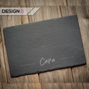 May include: Black slate serving board with the name "Cara" written in white on the surface.