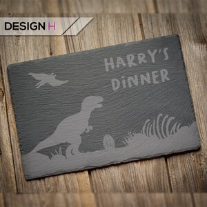 May include: A black slate serving tray with a dinosaur silhouette and the text "HARRY'S DINNER" in white.