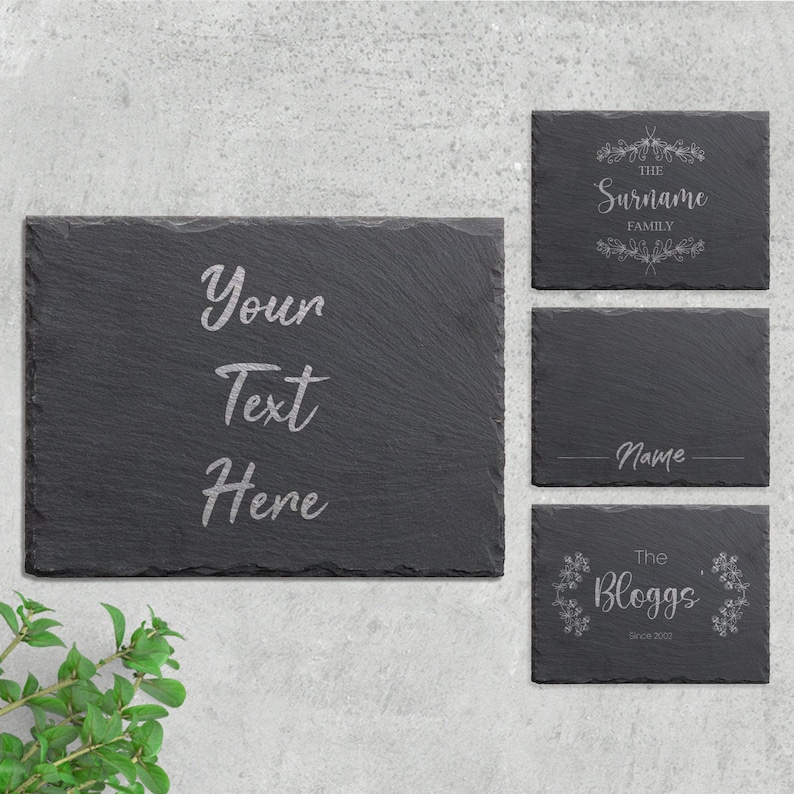 May include: Four black slate signs with white engraved text. The first sign says "Your Text Here". The second sign says "The Surname Family". The third sign says "Name". The fourth sign says "The Bloggs Since 2002".