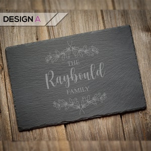 May include: Black slate serving tray with a decorative floral design and the text "The Raybould Family" engraved in white.
