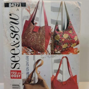 May include: A See & Sew B4271 sewing pattern envelope featuring illustrations of four different shoulder bags. The designs include a paisley print bag with red accents, a floral print bag, a solid brown bag, and a solid red bag with a strap.