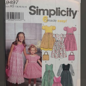 Könnte beinhalten: Eine Simplicity Schnittmusterhülle 9497 für Kinderkleider und Taschen. Das Cover zeigt Illustrationen verschiedener Kleidungsstile, darunter florale, karierte und einfarbige Designs sowie passende Handtaschen. Größe K5 7, 8, 10, 12, 14.