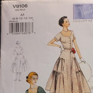 May include: Vintage Vogue dressmaking pattern with illustrations of two dresses. One is a light pink polka dot dress, the other a dark green dress. The pattern is labelled "Original 1952 Design" and includes French text.